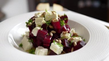 Pancar köklü sağlıklı salata, beyaz tabakta beyaz peynir ve ayçiçeği tohumları, kapatın, döndürür