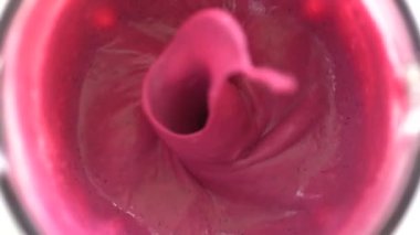 Tropical red dragon fruit and sweet banana with white coconut milk blended up into a healthy pink smoothie, fruit cocktail . The concept of a healthy lifestyle. Close up, slow motion, top view