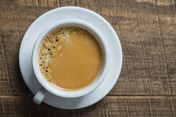 木製の背景にソーサー付きの白い磁器コーヒーカップ トップビュー コピースペース クローズアップ 朝食にホットコーヒー — ストック写真