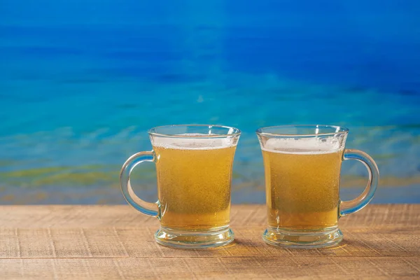 Dois Copos Cerveja Uma Praia Uma Mesa Madeira Com Fundo — Fotografia de Stock
