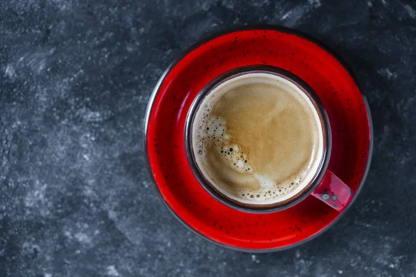 黒を背景にソーサー付きの赤い磁器コーヒーカップ トップビュー コピースペース クローズアップ 朝食にホットコーヒー — ストック写真