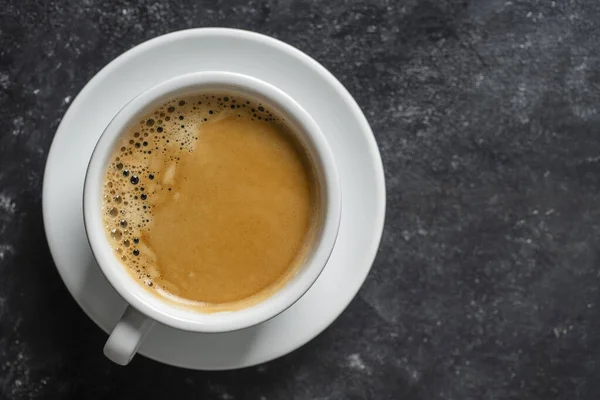 黒を背景にソーサー付きの白い磁器コーヒーカップ トップビュー コピースペース クローズアップ 朝食にホットコーヒー — ストック写真