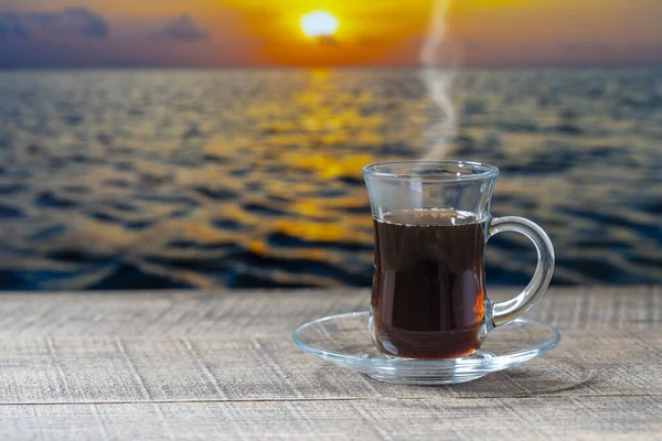 Kubek Szklanej Gorącej Czarnej Herbaty Drewnianym Stole Wodą Morską Podczas — Zdjęcie stockowe