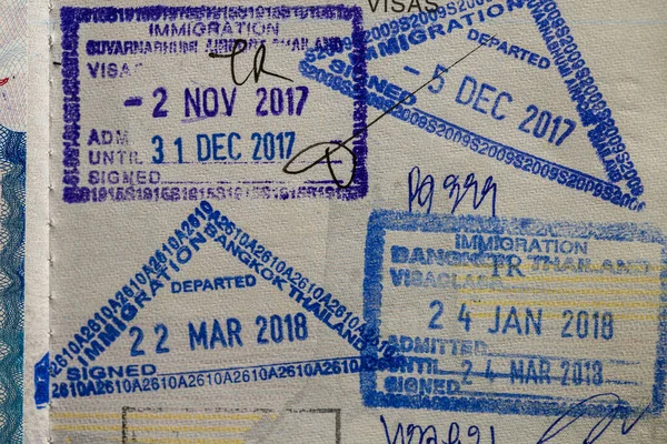 Inside page of a traveled Ukrainian passport with stamps from customs of Thailand. Border stamp in the passport when crossing the state border Thailand, close up. Vacation and travel concept
