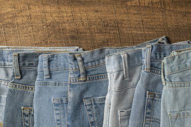 Bir sürü kot pantolon, yakın çekim. Denim geçmişi. Satın alma, satma, alışveriş ve modaya uygun modern kıyafetler