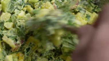 Şef, yeşil pırasa, haşlanmış yumurta, salatalık, turp, haşlanmış patates ve ekşi kremadan oluşan sağlıklı bir salata hazırlıyor. Haşlanmış yumurtalı yabani sarımsaklı salata.