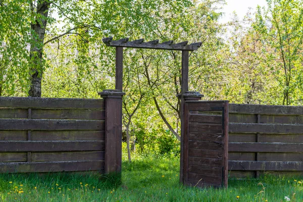 裏庭で春の日にオープンドアと緑の芝生と木製の庭のフェンス — ストック写真