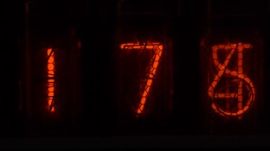 Cihazın üzerindeki vakum tüpü görüntüsü saniyeleri sayıyor. Vintage lamba zamanlayıcısında numaralar gösteriliyor, yakın çekim, nixie tüpü göstergesi. Parlama deşarj göstergesi