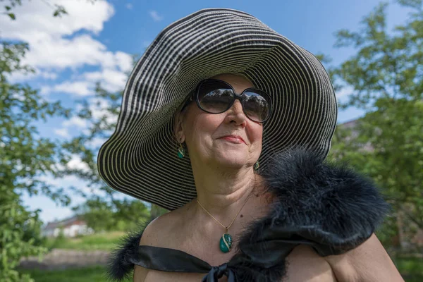 Doğanın Arka Planında Hasır Şapkalı Yaşlarında Mutlu Yaşlı Bir Kadının — Stok fotoğraf