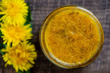 Olgun sarı karahindiba çiçeklerinden tatlı reçel, portakal, limon ve şeker, üst manzara, kapat. Karahindiba ünlü tıbbi bitki