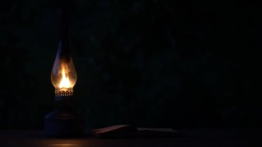 Eski antika yanan gaz lambası, ahşap masa üzerinde açık bir kitap, kapat, boşluğu kopyala