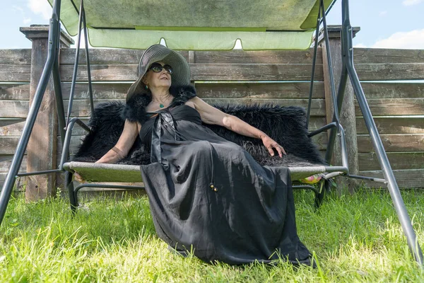 Yaşlarında Saman Şapkalı Mutlu Bir Kadının Portresi Bahçede Salıncakta Dinleniyor — Stok fotoğraf