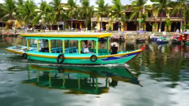 Hoi An, Vietnam - 29 Haziran 2020: Vietnamlılar Hoi Nehri kıyısındaki ahşap bir teknede yüzüyorlar.