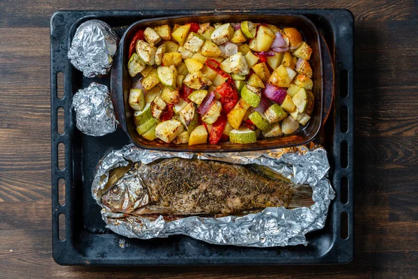 ベーキングシート上のオーブンで魚と野菜を混合焼き 閉じる 上のビュー — ストック写真