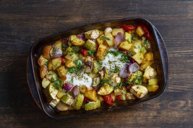 Fırında pişmiş sebzeyle yumurtanın karışımını cam bir tabakta pişirmek için, yakın çekim, üst manzara