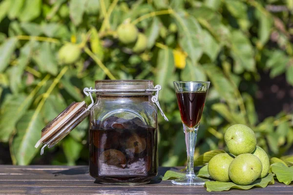 정원에서 테이블에 항아리에 호두의 냄비에 알코올에 미끄러지지 집에서 팅크를 준비하기 — 스톡 사진