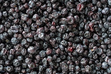 Arka planda kuru yaban mersini, yakın plan, üst manzara, makro. Vitaminleri korumanın bir yolu. Vejetaryen yemeği, sağlıklı ve yararlı. Kurutulmuş yaban mersini, yabanmersini