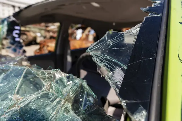 Close-up of the broken windshield of the car, transportation accident. An old abandoned car with a broken windows. Shards of broken and damaged car glass