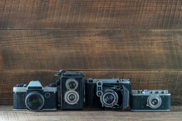 Set of vintage film camera from the times of the USSR on a wooden background, close up, copy space. Line of old retro cameras