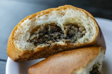 Beyaz tabakta mantarlı turta. Kapat.