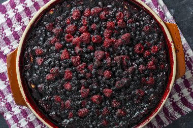 Masadaki seramik tabakta yabanmersinli ve ahududulu turta.