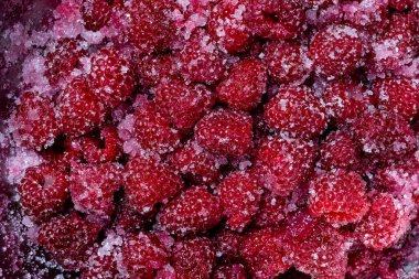 Taze kırmızı ahududu, granüle şeker ile kaplı reçel hazırlama kasesi, üst manzara, yakın çekim. Şekerli ahududu arkaplan ve dokusu