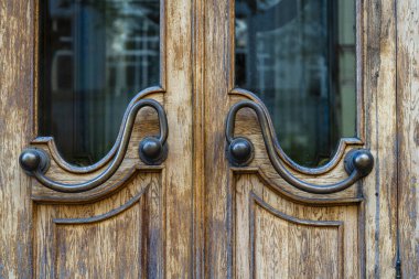 Bronz saplı ve camlı eski koyu kahverengi kapılar. Pencereleri sokak yansımalı ahşap kapı, kapat