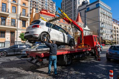 Kyiv, Ukrayna - 19 Eylül 2023: Çekici Ukrayna 'nın başkenti Kyiv' de yanlış park edilmiş bir arabayı aldı. Trafik kurallarının ihlali. Şehir caddesinden bir arabayı tahliye etmek.