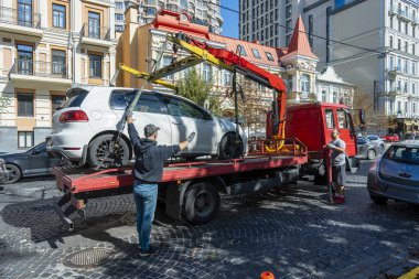 Kyiv, Ukrayna - 19 Eylül 2023: Çekici Ukrayna 'nın başkenti Kyiv' de yanlış park edilmiş bir arabayı aldı. Trafik kurallarının ihlali. Şehir caddesinden bir arabayı tahliye etmek.