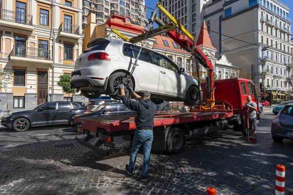 Kyiv, Ukrayna - 19 Eylül 2023: Çekici Ukrayna 'nın başkenti Kyiv' de yanlış park edilmiş bir arabayı aldı. Trafik kurallarının ihlali. Şehir caddesinden bir arabayı tahliye etmek.