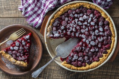 Ahşap zemin üzerinde seramik bir tabakta ahududu turtası, yakın plan, üst manzara