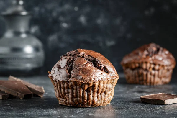 Chocolate muffin on dark background, close up. Homemade delicious chocolate muffins on black board