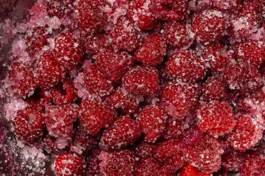 Taze kırmızı ahududu, granüle şeker ile kaplı reçel hazırlama kasesi, üst manzara, yakın çekim. Şekerli ahududu arkaplan ve dokusu