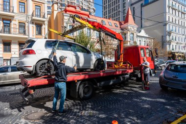 Kyiv, Ukrayna - 19 Eylül 2023: Çekici Ukrayna 'nın başkenti Kyiv' de yanlış park edilmiş bir arabayı aldı. Trafik kurallarının ihlali. Şehir caddesinden bir arabayı tahliye etmek.