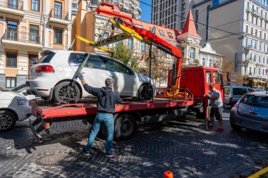Kyiv, Ukrayna - 19 Eylül 2023: Çekici Ukrayna 'nın başkenti Kyiv' de yanlış park edilmiş bir arabayı aldı. Trafik kurallarının ihlali. Şehir caddesinden bir arabayı tahliye etmek.