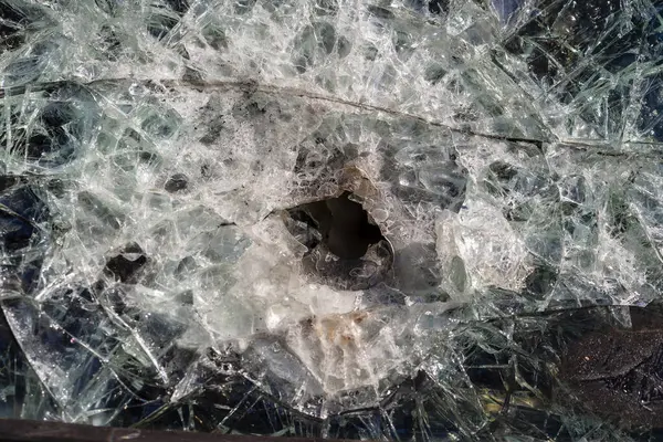 アーマーピアスガラスの弾丸穴 ロシアとウクライナの戦争中に損傷した軍歩兵戦闘車両のアーマーピアスガラス 攻撃後のバックグラウンドとテクスチャ防弾ガラス — ストック写真