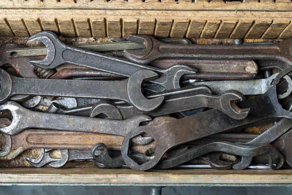 Wooden tool box of hand tools with old and dirty, rusty wrenches, ring spanners and other do-it-yourself for diy, close up, top view