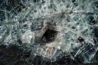 Zırh delici camda kurşun deliği. Rusya ve Ukrayna arasındaki savaş sırasında hasar görmüş askeri piyade savaş aracının zırh delici camı. Saldırı sonrası arka plan ve doku camları kurşun geçirmez.