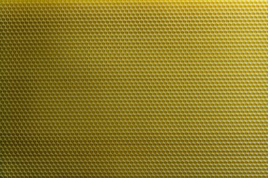 Bal dolu bir arı kovanından alınan balmumu bal peteğinin arka plan dokusu ve şablonu. Voshchina bal peteği yapımında yapay bir temel, hücrelerin balmumu tabakası