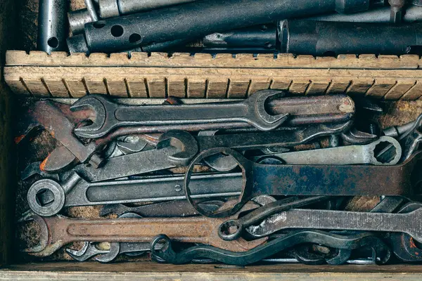 Wooden tool box of hand tools with old and dirty, rusty wrenches, ring spanners and other do-it-yourself for diy, close up, top view