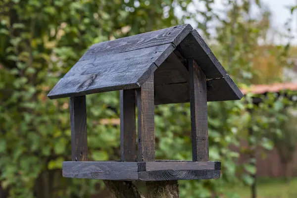 秋天花园上一幢房子的木鸟喂食器 — 图库照片