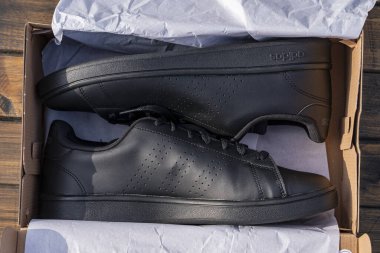 Kyiv, Ukrayna - 05 Ekim 2023: Güzel yeni Adidas kutuda tam siyah ayakkabılar, kapat, üst manzara