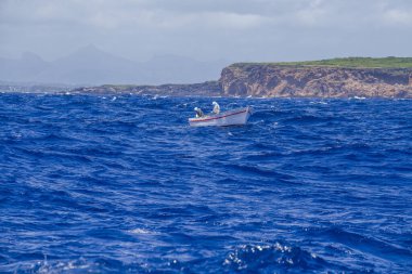 Mauritius adasında Hint okyanusunda yüzen bir balıkçı teknesinin görüntüsü. Fırtınalı mavi deniz dalgalarında yüzüyor