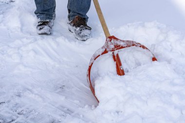 Kışın karları kürekle temizleyen adam, kapat. Kışın kar temizleme servisini kar fırtınası üstüne kürekle temizlemek.