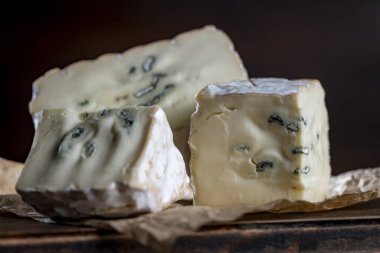 Ahşap bir masada mavi peynir dilimleri, yakın çekim.