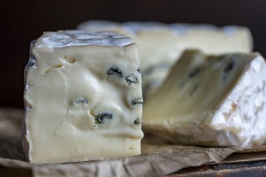 Ahşap bir masada mavi peynir dilimleri, yakın çekim.