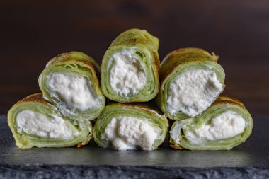 Yeşil vejetaryen börekleri, tabakta ıspanaklı krep, yakın çekim. Sağlıklı kahvaltı kavramı