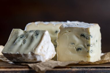 Ahşap bir masada mavi peynir dilimleri, yakın çekim.