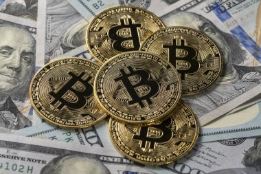100 dolarlık banknotların üzerindeki altın bitcoin kripto paralarını kapatın. Elektronik merkeziyetçi para konsepti. Bitcoin 'i bir dolarla değiş tokuş et. Bitcoin para ve nakit arkaplan