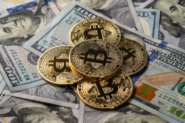 100 dolarlık banknotların üzerindeki altın bitcoin kripto paralarını kapatın. Elektronik merkeziyetçi para konsepti. Bitcoin 'i bir dolarla değiş tokuş et. Bitcoin para ve nakit arkaplan